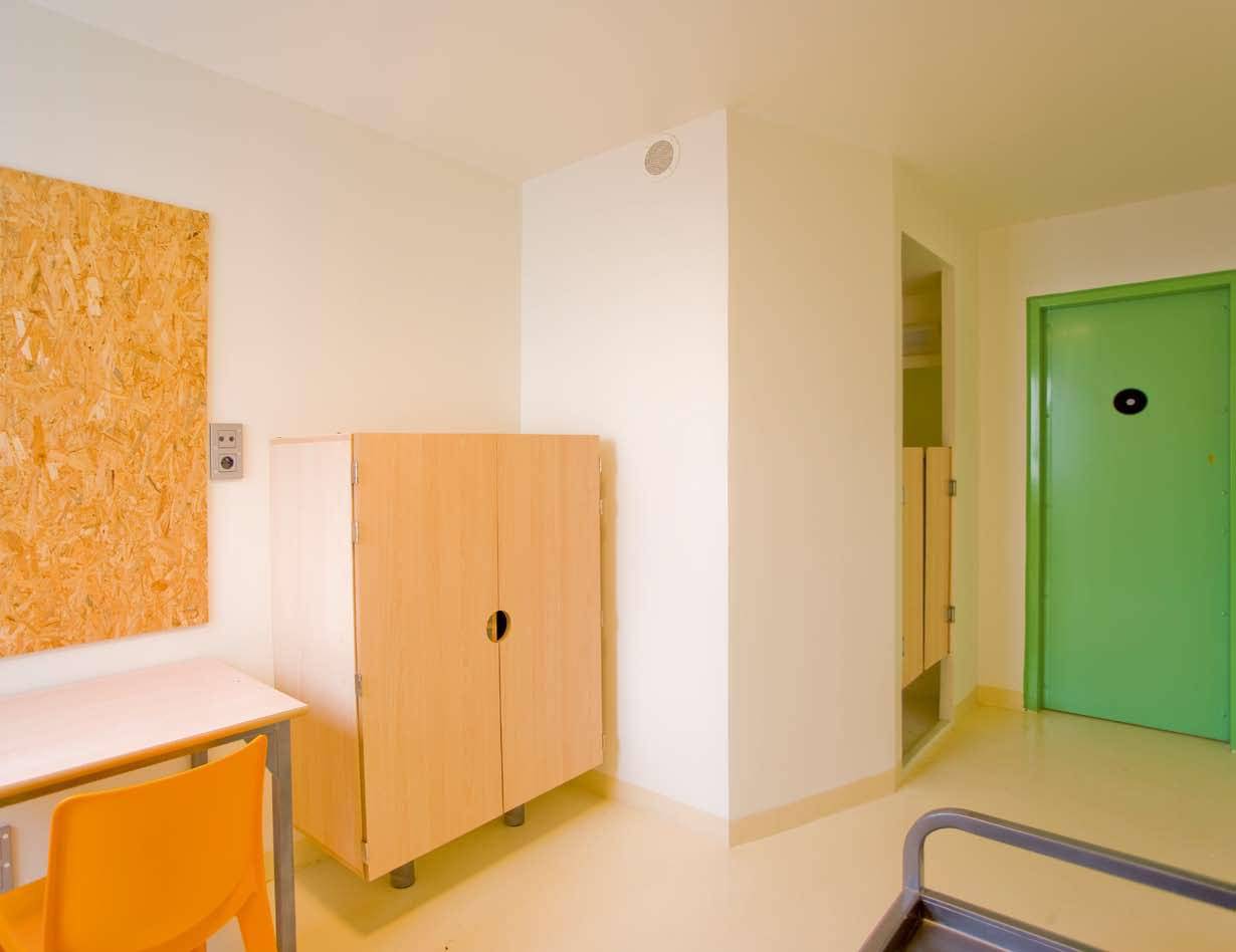 Aménagement d'une cellule de prison avec mobilier en bois et métal à Roanne dans la Loire